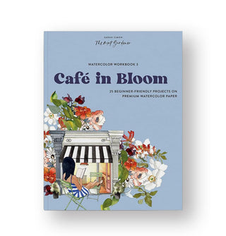 Blue cover of Watercolor Workbook 3: Café in Bloom features an elaborate and colorful illustration of a woman reading in front of a building facade with a black and white striped awning and surrounded by florals