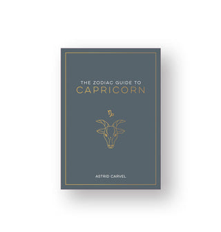 Gray-green cover of The Zodiac Guide to Capricorn by Astrid Carvel features white and gold lettering and a central illustration of the sea-goat