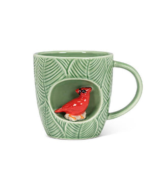 Green mug with leaf texture features a circular alcove with a red cardinal figurine inside