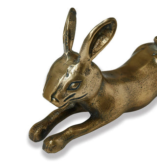 Closeup of antiqued brass-effect rabbit sculpture's ears, face, and front paws