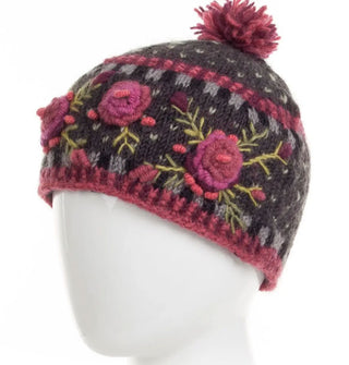 Charcoal wool beanie with textural pink, purple, and green floral embroidery, geometric border designs, and a two-tone purple pom pom on top
