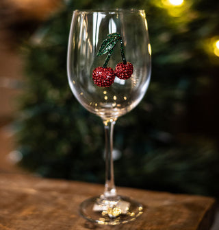 Clear wine glass with green and red rhinestone cherries decal on its bowl