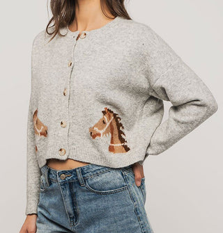 Model wears a gray cardigan with mirrored brown bridled horse designs near the bottom hem on either side of a 5-button placket