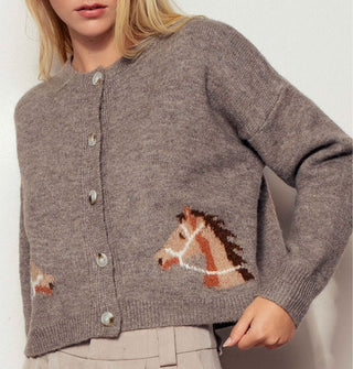 Model wears a dark grayish-brown cardigan with mirrored brown bridled horse designs near the bottom hem on either side of a 5-button placket