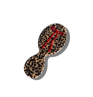 Small hairbrush with leopard-like tortoise finish features a hand-painted red bow design on its paddle