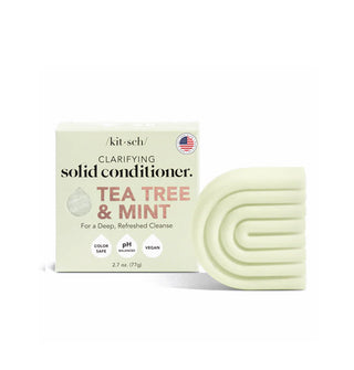 Light green ribbed C-shaped bar of Kitsch Clarifying Tea Tree & Mint Solid Conditioner next to its box packaging