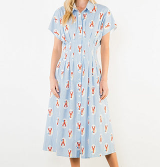 Model wears a short-sleeved button-down blue pinstripe shirt dress and a print of lobsters in white ovals