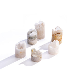 Collection of cylindrical quartz pillars with rough tops, each different heights and with varying colorations