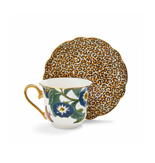 White floral-patterned teacup with gold rim and handle alongside a leopard print saucer with scalloped edge placed on end