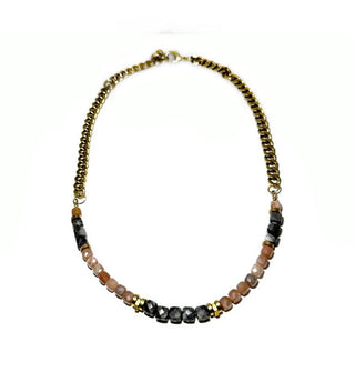Necklace which is half faceted charcoal-colored larvikite stones and peach moonstone with brass separators and half chunky brass curb chain