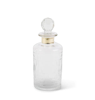 Cylindrical faceted glass decanter with gold band around the neck and a rounded stopper