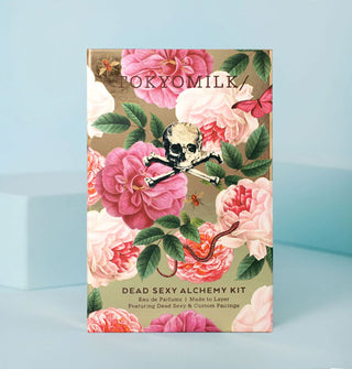 TokyoMilk Dead Sexy Alchemy Kit box designed with lush pink florals, green leaves, bees and butterflies, a snake, and a central skull and crossbones insignia