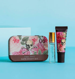 Dead Sexy Date Night Kit tin with floral pattern and skull and crossbones insignia alongside a glass bottle of TokyoMilk perfume and matching floral lip balm tube