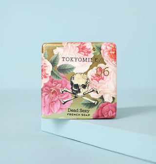 Square TokyoMilk Dead Sexy French Soap bar is wrapped in floral paper with a skull and crossbones drawing