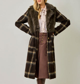 Model with hands on hips wears a brown and tan plaid brushed fiber coat with solid brown faux fur bodice
