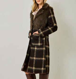 Model wears a brown and tan plaid brushed fiber coat with solid brown faux fur bodice and front pockets