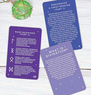 Sample Divination Cards, all in blue or purple tones with white lettering are staged on a white wooden surface with gold pentagram-wrapped green pendant