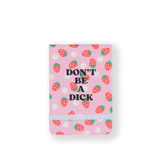 Rectangular pink notebook cover patterned with strawberries and daisies and held closed with an elastic band says, "Don't be a dick" in bold, black lettering