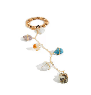 A gold chain fitted with five wire-wrapped rough-cut gemstones is attached to a gold wire-wrapped black elastic hair tie