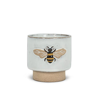 Grey ceramic pot with matte brown pedestal base and embossed bee graphic on the side