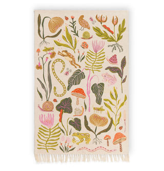 Cream-colored rectangular dish towel with one tasseled side features colorful floral, mushroom, frog, and insect embroidery