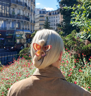Model wears a butterfly claw clip in a twist updo