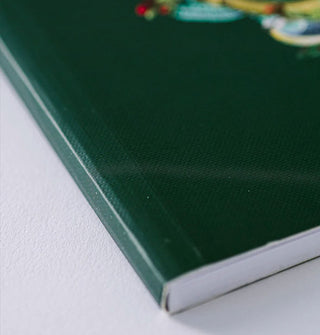 Closeup of a dark green notebook's cover texture and binding