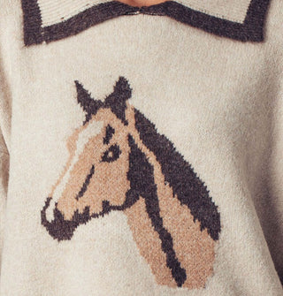Brown and blue horse head design on a white sweater with wide blue-edged collar