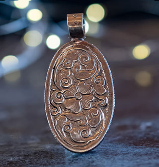 Pendant back features ornate floral and leaf engraving