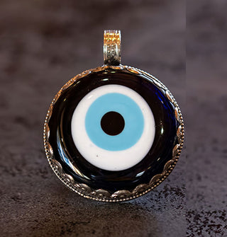 Blue vil eye necklace pendant in silver setting with carved, rounded top bail