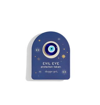 Dark blue arched card  with star and eye accents holds a blue and white glass Evil Eye Protection Token