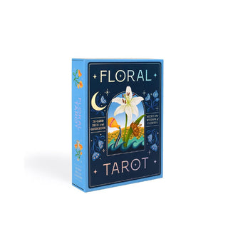 Dark blue box of Floral Tarot cards with light blue edge features a central white lily illustration surrounded by celestial symbols and flower accents