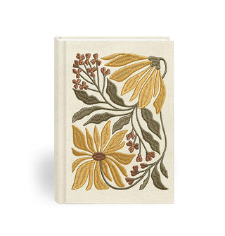 White fabric hardcover journal features floral embroidery in a muted yellow, green, and brown color palette