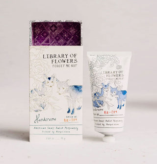 White slide box and tube of Library of Flowers Forget Me Not Handcreme feature monochromatic illustrations of foxes and florals; the box interior features purple patterning