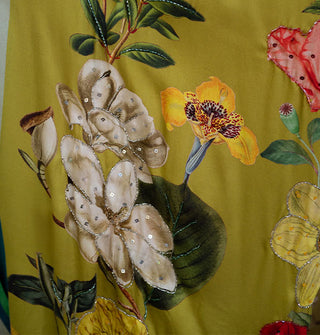 Closeup of sequins and beads accenting the floral print of olive green kimono robe fabric