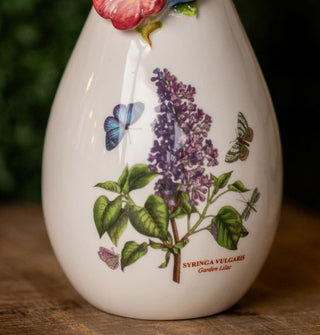 Detail of the lilac illustration on a white ceramic vase includes the caption, "Syringa vulgaris"