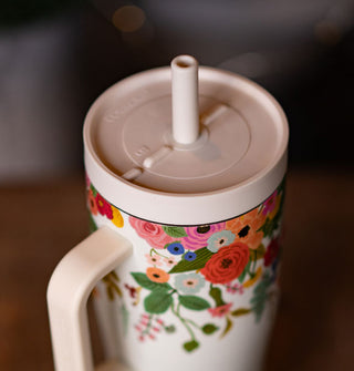 Top view of the lid and straw of a white thermos with colorful floral designs