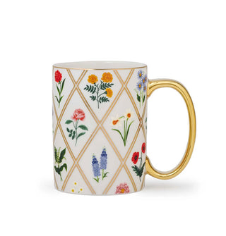 White porcelain mug with gold handle and rim features colorful floral designs in the spaces of a gilded diamond pattern