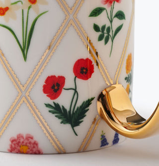 Closeup of red poppies on a white porcelain mug with gold foil details