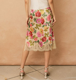 Model wears a knee-length floral-patterned skirt with lace hem