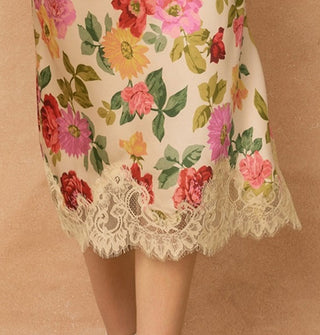 Model wears a knee-length floral-patterned skirt with lace hem
