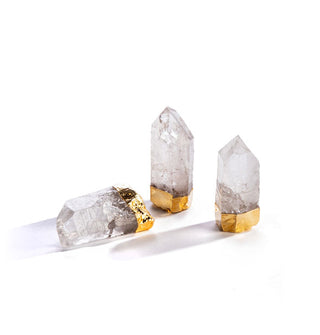 Grouping of three clear crystal quartz points with gilded bases; two are standing upright and the other is on its side