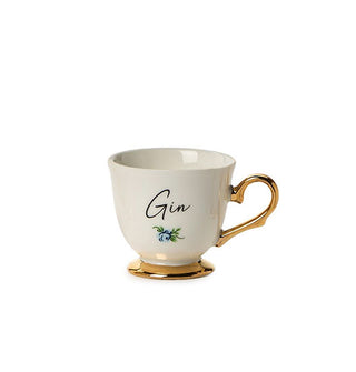 Small porcelain teacup with gold base and handle says, "Gin" in black script with a small flower design underneath