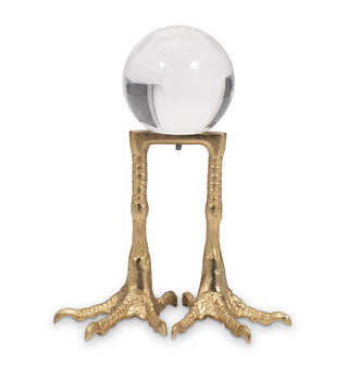 Clear acrylic orb on a gold stand designed to resemble bird's feet