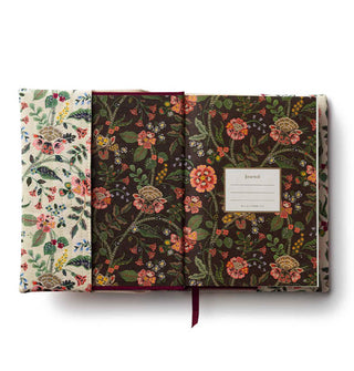 Opened journal with a dark floral interior print and light floral exterior cloth cover