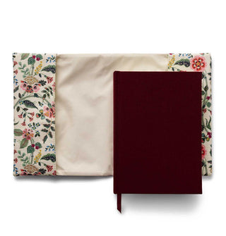 Dark brown hardcover journal with light floral patterned cloth clover, shown open underneath