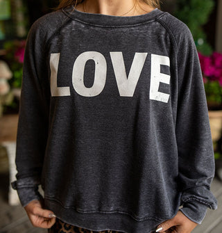 Model wears a dark gray distressed-effect sweatshirt that says, "LOVE" in large white letters