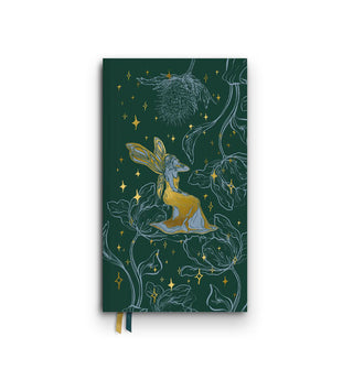 Dark green journal cover features a central gold foil-accented fairy amid gold stars and large floral line drawings in blue; gold and green ribbon bookmarks extend from the bottom