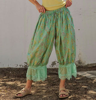Model wears a pair of green floral print pantaloons with lace trim and an elastic tie waist