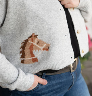 Closeup of the brown horse head detail on a gray button-down cardigan
